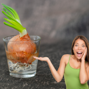 Una cebolla germinando en un vaso de agua con una mujer sorprendida
